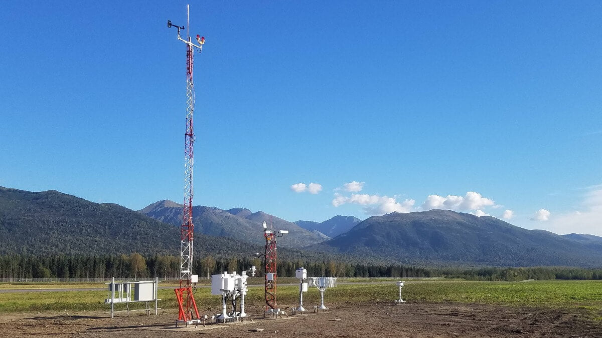 Mesotech AWA Automated Weather Observing System AWOS IIIPT airport weather station in a lush mountain landscape.