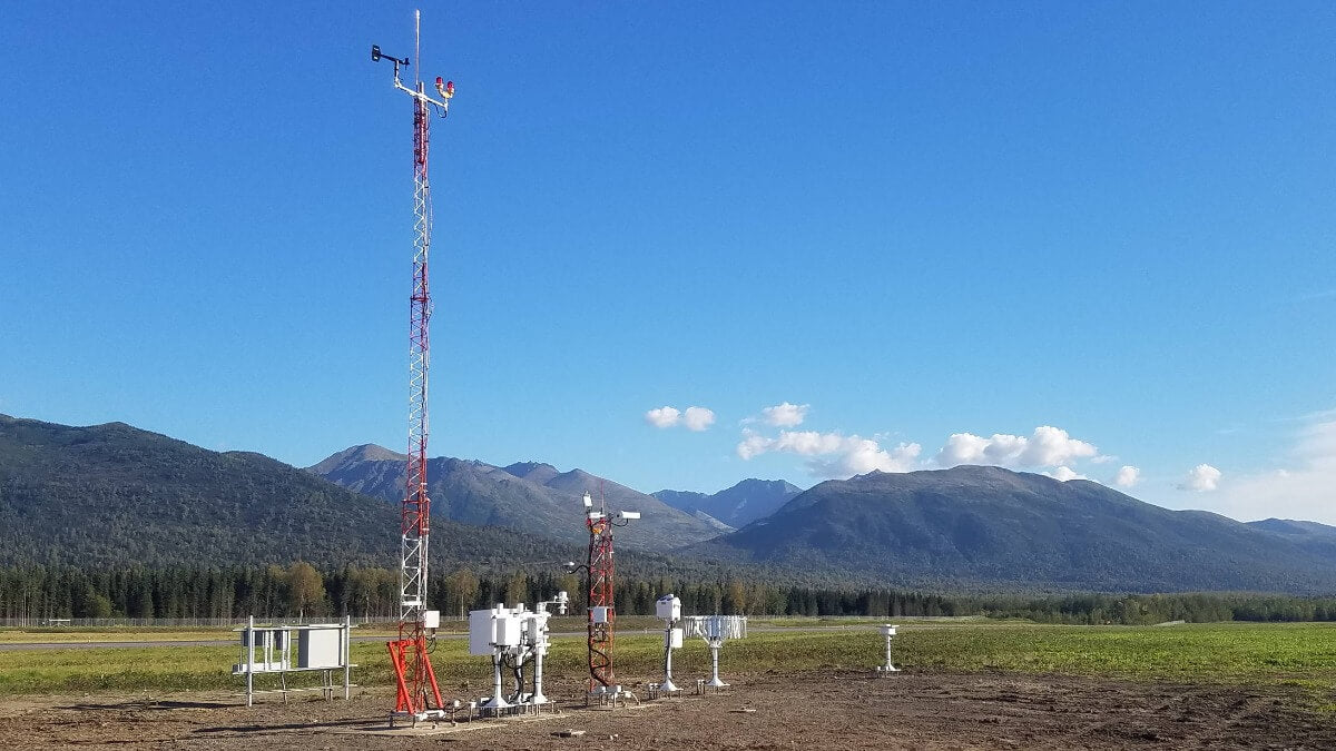 Mesotech AWA AWOS IIIPT airport weather station in a lush mountain landscape.